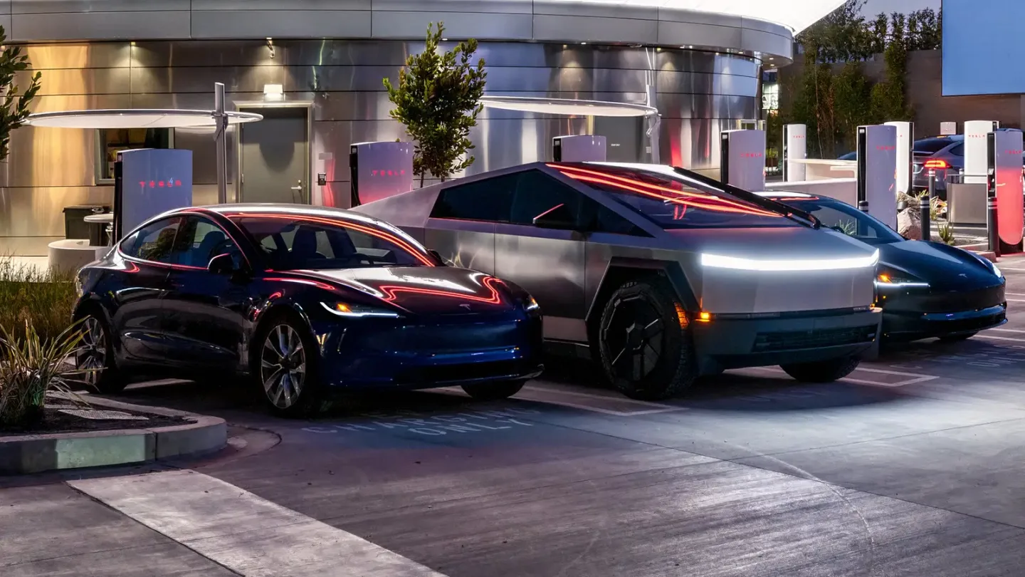 Bir şarj alanında Tesla sedan, Tesla Cybertruck ve başka bir elektrikli araç park halinde.