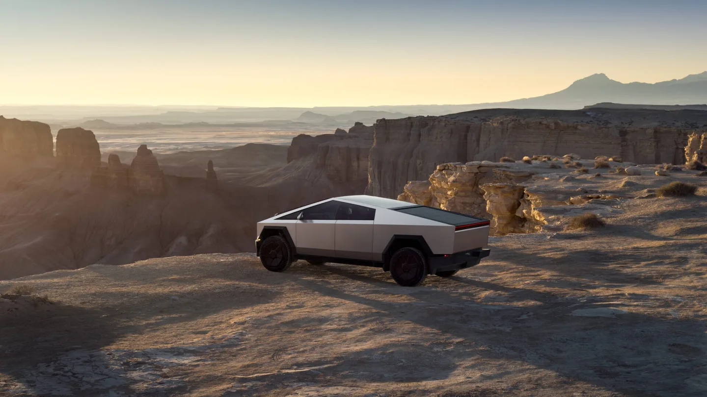 Kayalık bir arazide duran gümüş renkli Tesla Cybertruck.