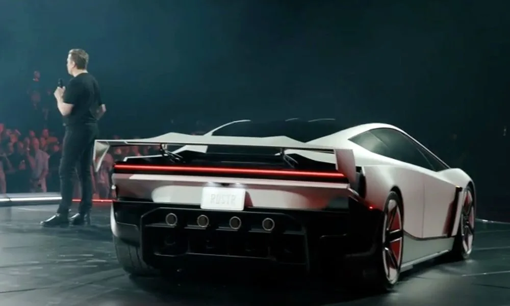 Elon Musk sahnede, arkasında Tesla Roadster’ın arka kısmı görünüyor.
