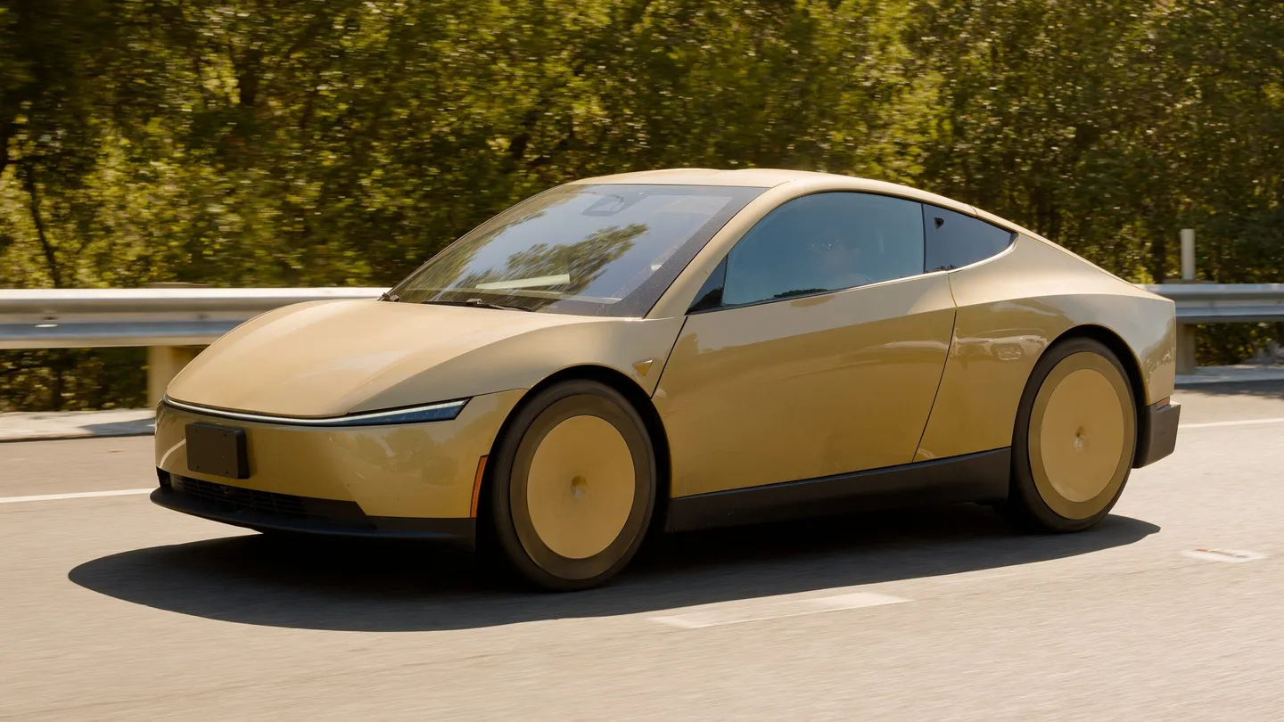 Altın renkli Tesla Cybercab yol üzerinde ilerliyor.